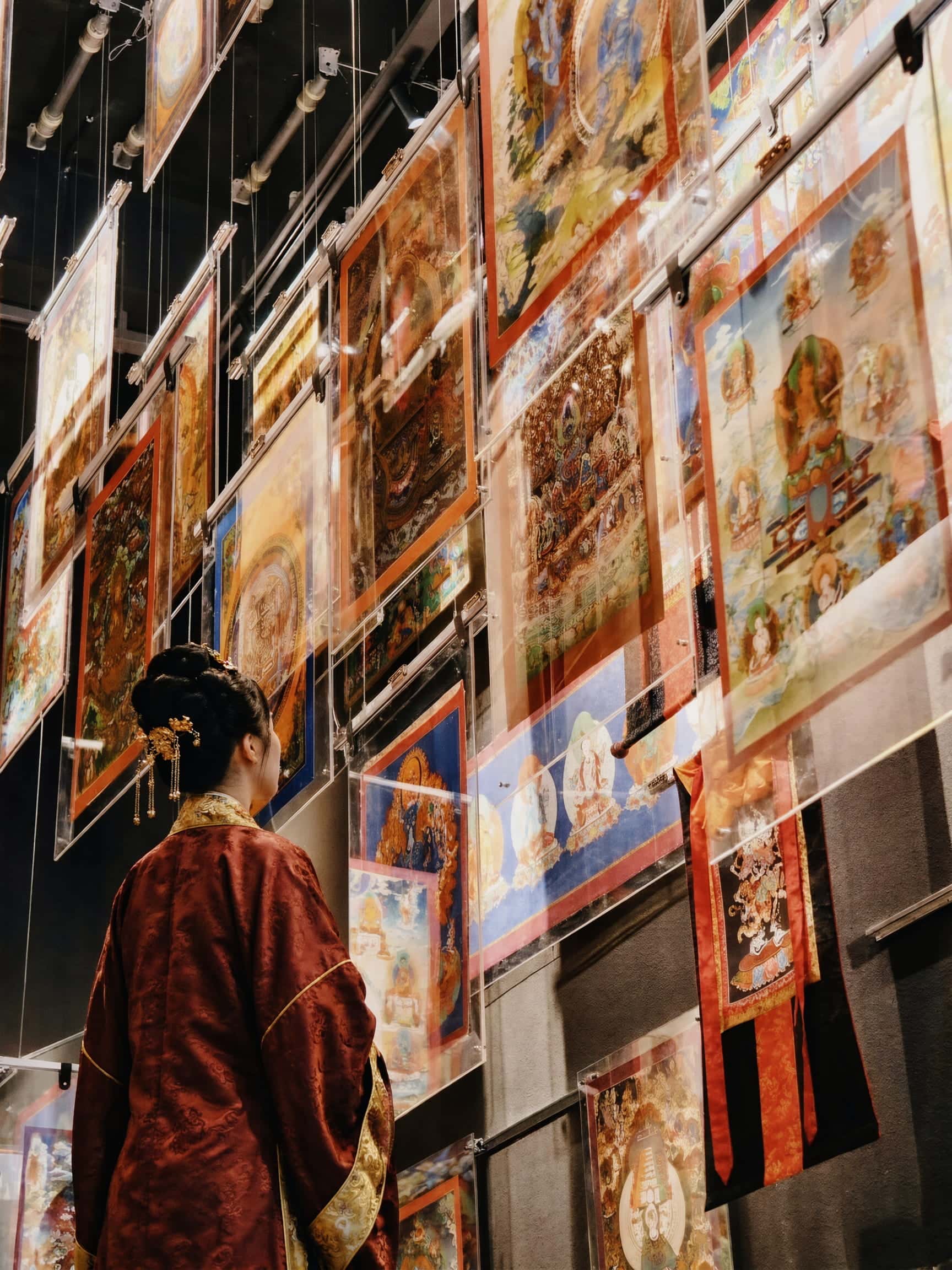 Art collector admiring authentic handcrafted thangkas in a museum exhibition gallery, healing wall art for anxiety, peaceful energy and mindful living